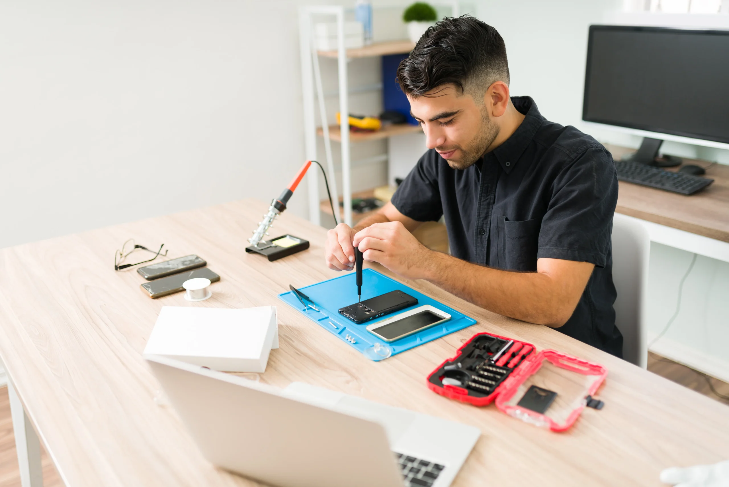 young-man-repairing-old-smartphone-male-technician-using-screwdriver-fix-broken-cellphone